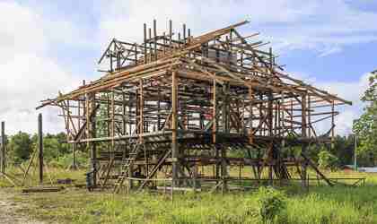 A timber house frame under construction.